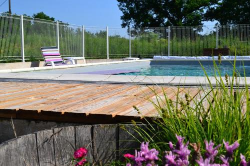 - une piscine avec une terrasse et une chaise dans l'établissement Couanac gîte familial à la campagne avec piscine, à Cayriech