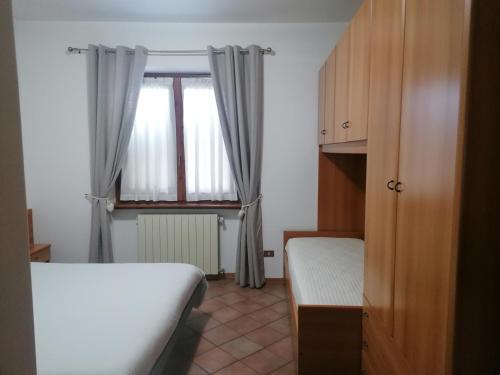 a small room with a bed and a window at Sweet Home Casa Vacanze "Il Bilocale" in Songavazzo