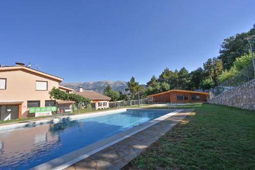 a swimming pool in a yard next to a house at Bungalows del Camping Pedraforca in Saldés