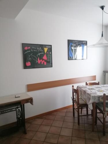 a dining room with a table and a chalkboard on the wall at Sweet Home Casa Vacanze "Il Bilocale" in Songavazzo