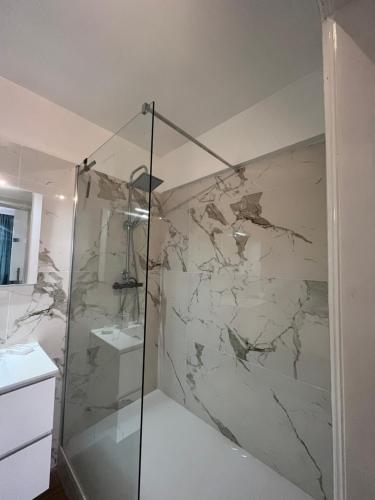 a bathroom with a shower with a marble wall at Amajed in Namur