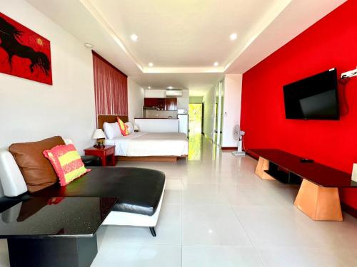 sypialnia z łóżkiem i czerwoną ścianą w obiekcie Mountain Seaview Luxury Apartments w mieście Kata Beach