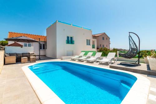 a swimming pool in front of a villa at Holiday Home Sevid in Sevid