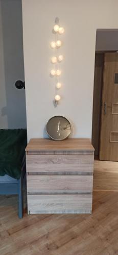 a clock on top of a dresser in a room at Daszyńskiego 7m3 in Krakow