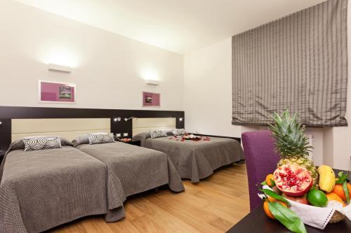 Habitación de hotel con 2 camas y un bol de fruta en Domus Best Guest House, en Roma