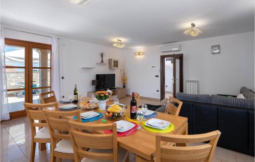 a dining room with a wooden table and chairs at Nice Home In Hr-52215 Vodnjan in Vodnjan