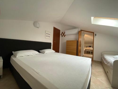 a bedroom with a large white bed and a mirror at Luci in San Vincenzo
