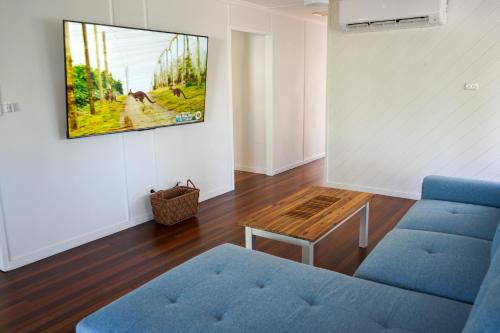 a living room with a blue couch and a table at The Beach House at Pallarenda in Pallarenda