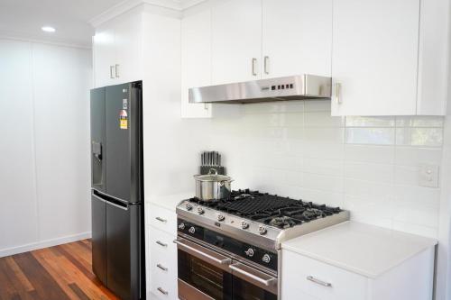 a white kitchen with a stove and a refrigerator at The Beach House at Pallarenda in Pallarenda