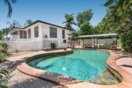 a swimming pool in front of a house at The Beach House at Pallarenda in Pallarenda