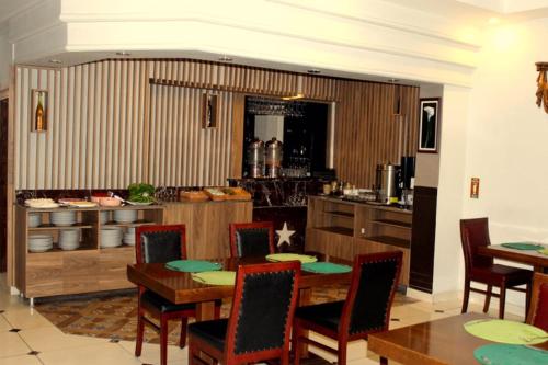a dining room with a table and a kitchen at Hotel Anibal in Gebze