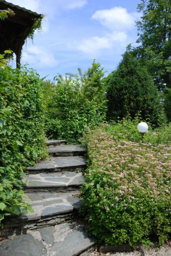 a stone path in a garden with bushes at Appartements im Park in Krumpendorf am Wörthersee