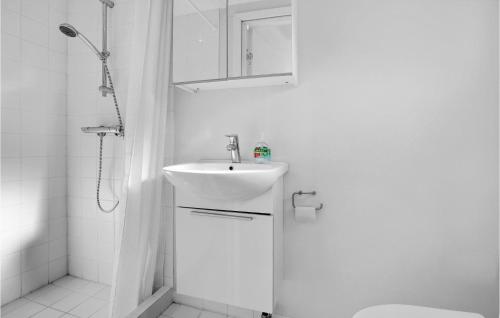 een witte badkamer met een wastafel en een douche bij Lovely Home In Allinge With Wifi in Allinge