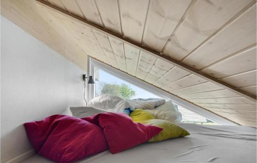 Cette chambre dispose d'un lit avec des oreillers colorés et d'une fenêtre. dans l'établissement 3 Bedroom Lovely Home In Jgerspris, à Jægerspris