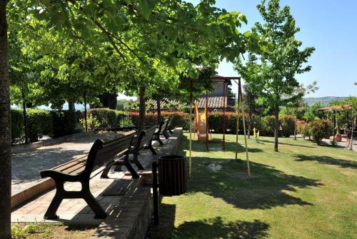 a row of benches in a park with trees at Agriturismo Tenuta Badia in Paciano