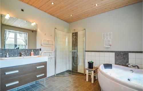 a bathroom with a tub and a shower and a sink at Nice Home In Toftlund With 3 Bedrooms And Wifi in Vestergård