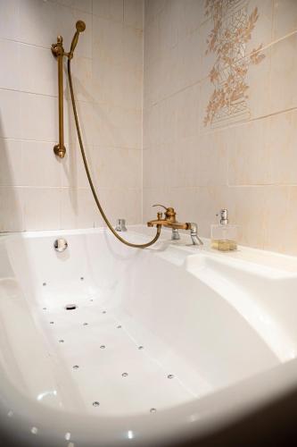 une salle de bain avec une baignoire et un lavabo dans l'établissement Hotel Du Parc - Manoir Du Baron Blanc, à Faverges