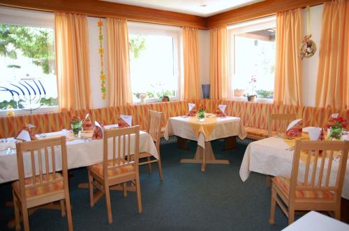 a dining room with tables and chairs and windows at Landhotel Krone in Oberreute