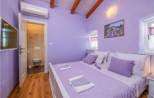 um quarto com uma cama grande e paredes roxas em Awesome Home In Pula With Wifi em Valtura