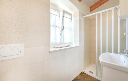 uma casa de banho branca com um lavatório e uma janela em Awesome Home In Pula With Wifi em Valtura