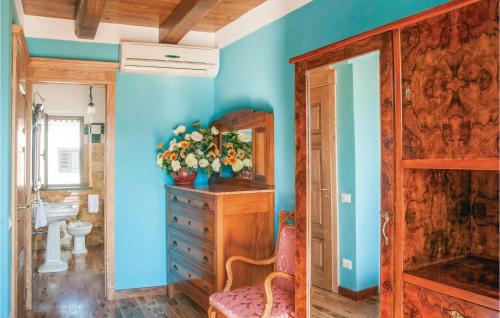 La salle de bains est pourvue de murs bleus, d'une armoire en bois et d'une chaise. dans l'établissement La Villa Del Sole, à Vibonati