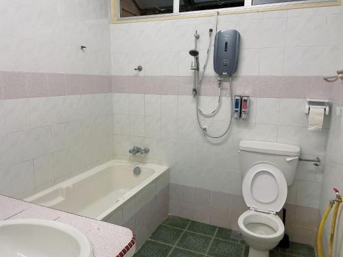 a bathroom with a toilet and a phone on the wall at Greenlane 4-bedroom landed home (12 pax) in Gelugor