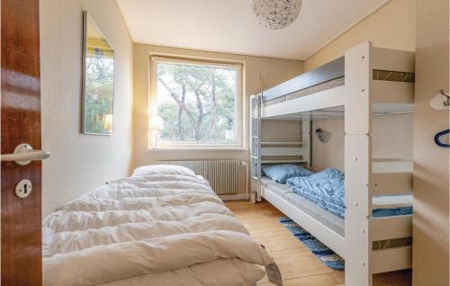 1 dormitorio con 2 literas y ventana en 3 Bedroom Beautiful Home In Nex, en Spidsegård