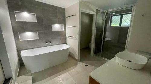 a bathroom with a tub and a toilet and a shower at Saunders Beach Holiday House 