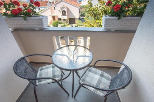 a table and two chairs on a balcony with flowers at Villa Valentina in Zadar