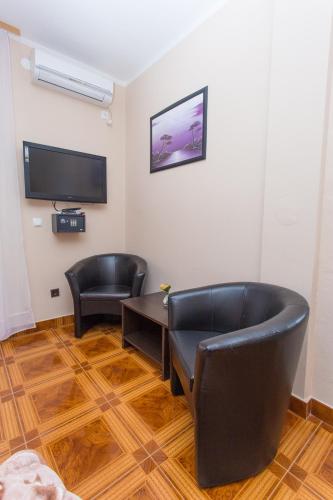 a room with two chairs and a table and a television at Villa Valentina in Zadar