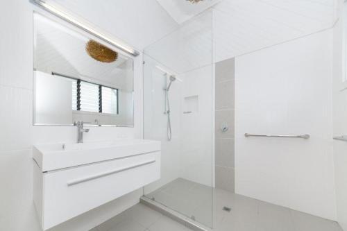 a white bathroom with a sink and a shower at Denham Heights in Townsville