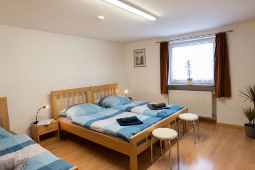 1 dormitorio con cama con sábanas azules y ventana en Ferienwohnung am Bach, en Oberkotzau