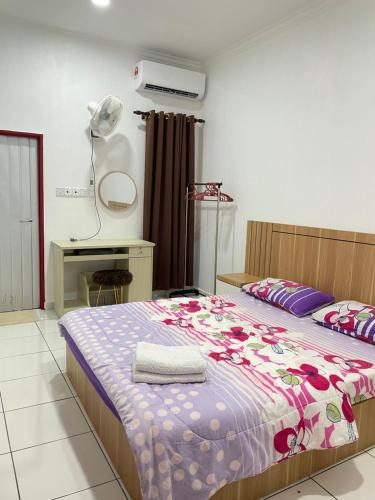 a bedroom with a bed and a desk in it at D’Aliff Pamalan Homestay Keningau in Keningau
