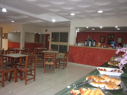 Pousada Águas de Lindoia في أغواس دي يندويا: مطعم بطاولات وكراسي وطاولة طعام