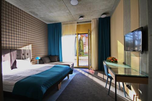 une chambre d'hôtel avec un lit et une télévision dans l'établissement Kurshi Hotel & Spa, à Jurmala
