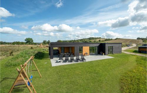 a black house on a hill with a playground at 4 Bedroom Stunning Home In Løgstrup in Løgstrup