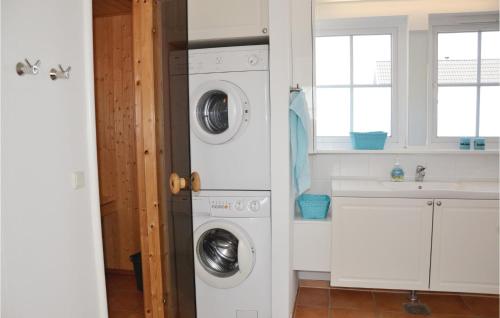 - une buanderie blanche avec lave-linge et sèche-linge dans l'établissement 3 Bedroom Cozy Home In Vejby, à Vejby