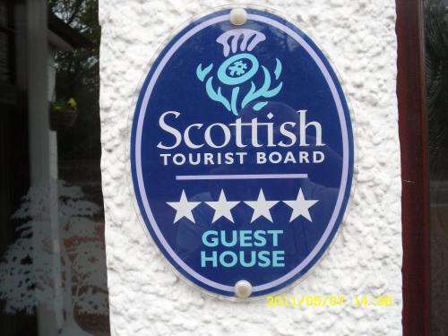 a blue and white sign on a white wall at Acer Lodge Guest House in Edinburgh