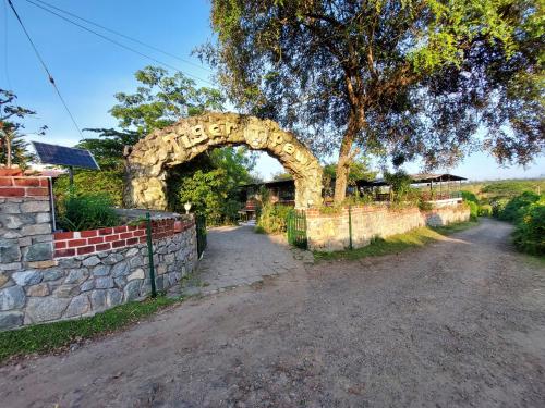 an arch in a stone wall next to a road at THE TIGER PAW RESORT in Masinagudi