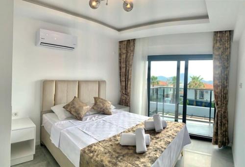 - une chambre avec un grand lit et un balcon dans l'établissement Nokta Park I 4+1 Villa, Özel Havuzlu, à Fethiye