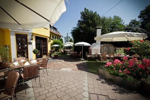 an outdoor patio with tables and chairs and umbrellas at Römerhof in Stuttgart