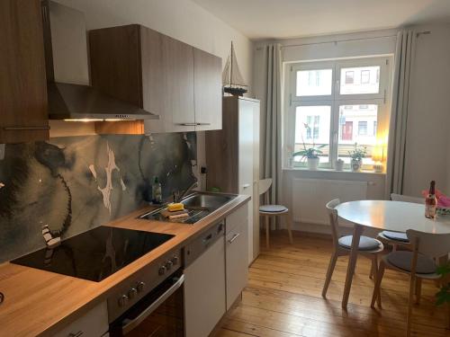 eine Küche mit einem Waschbecken und einem Tisch darin in der Unterkunft Altstadt Ferienwohnung in Brandenburg an der Havel