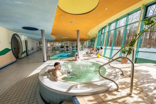 a boy in a hot tub in a building at Hotel Seehof Haltern am See in Haltern