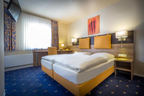 a hotel room with a large bed and a window at Römerhof in Stuttgart