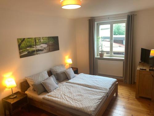 ブランデンブルク・アン・デア・ハーフェルにあるAltstadt Ferienwohnungのベッドルーム1室(白いシーツ付きのベッド1台、窓付)