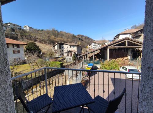 a balcony with two chairs and a view of a town at Hotel Bed & Bike Ledro in Molina di Ledro