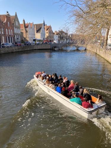 a group of people riding in a boat on a river at Mansion9Bruges in Bruges