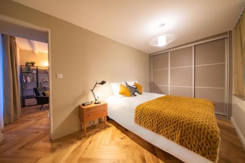 梅斯的住宿－La suite du Graou，一间卧室配有一张床和一张桌子上的台灯