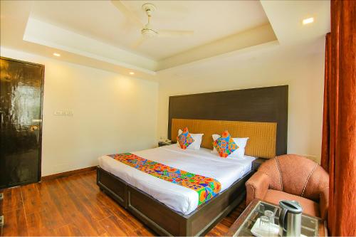 a bedroom with a large bed and a chair at FabHotel Dwaper in Mussoorie