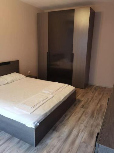 een bed in een slaapkamer met een houten vloer bij Прекрасен апартамент в София in Sofia